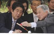 Akihito teaches Shinzo Abe how to play paddle ball.