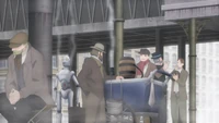 A stall along a corner of a street in the anime.