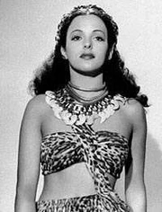 Acquanetta standing in a leopard skin top