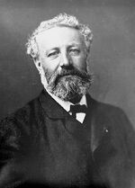 Black-and-white photo of man in formal dress with unkempt hair, moustache and beard.