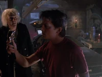 Marty examining the top of Biff's cane, which Doc had found in the DeLorean.