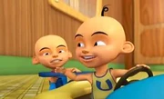 Upin memandu kereta mainan dengan pacuan Ipin.