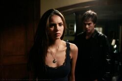 Damon se esgueirando por trás de Elena.