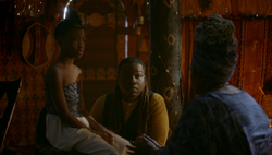 Cleo and her grandmother talk whilst Kaleb watches.