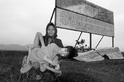 Two Vietnamese pose in front of the billboard