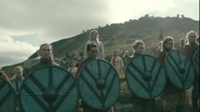 Shield-maidens carrying the shield banner of Hedeby: a Fe-bindrune (signifying wealth) on a blue field.