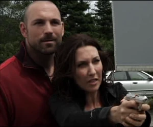 Molly holding Bruce at gunpoint