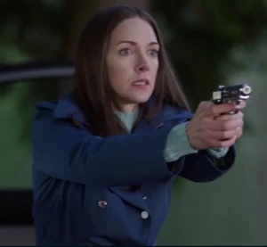 Sharon wielding her gun during her reveal