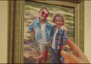 Dean pointing his finger at a picture of Jeremy and Rose as children.