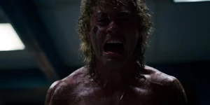 Billy screaming ferociously before El throws him into a brick wall.