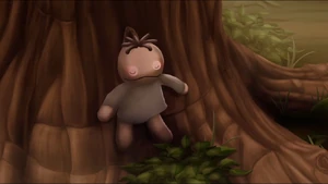 One of the dolls in the trunk of a tree.