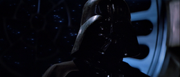 Vader walks to his master's side who is torturing Luke with Force lightning.