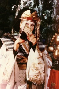 The Queen disguised as an evil Japanese geisha.