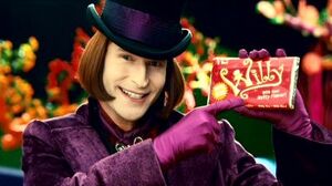 Willy's evil grin as he holds a chocolate bar.