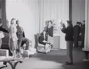 Grover getting his picture taken just as he grabs and kidnaps Joan in the dark