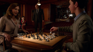 Young Lex plays chess with Lillian when Lionel brings Lena home for the first time.