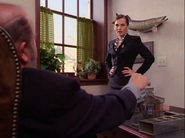 Lucre listening to Miss Arbitrage speak while placing coins in a machine