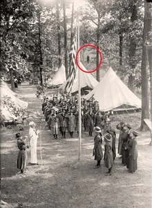 Slender man in the background of a military camp.