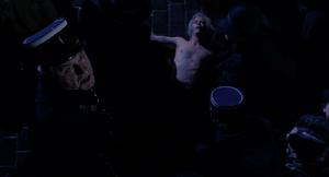Dr. Jekyll's corpse laying on the ground as a police sergeant calls Van Helsing a murderer.