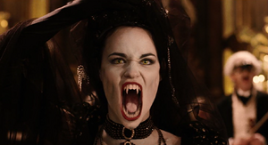 The opera singer removes her mask and her canines become fangs, snarling.
