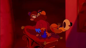 Iago being silenced by Abu to prevent him from alerting Jafar of Aladdin's presence.