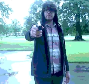 The Carver (in the form of Luke Anton), pointing a gun at Michael.