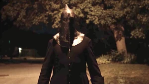 Cam as The Executioner appears in front of Malcolm.