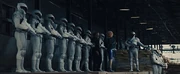 Peacekeepers stand guard at a train station in District 11.