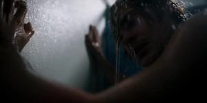 Billy taking a shower where he notices black veins forming on his arm.