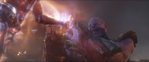 Thanos pulls the Power Stone out of the Gauntlet.
