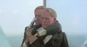 Dick Jones holding the Old Man hostage after his cover is blown and about to be fired by the latter.