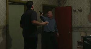 Phil forces Dan into the apartment where Mel is being held captive (2001).