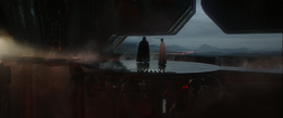 Vader discusses the situation with Krennic on a platform overlooking the volcanic landscape of the planet.