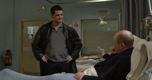 Phil is visited by Dan in hospital after the former has been shot by an unknown assailant (2001).