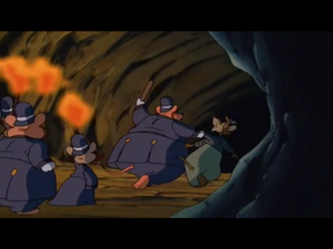 McBrusque abusing Scuttlebutt as the two along with the police mice enter the Indian cave.