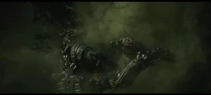 Lockdown tries to catch Optimus Prime's foot down with a big hook.