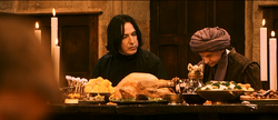 Quirrell at the feast at Hogwarts, seated next to his rival Snape