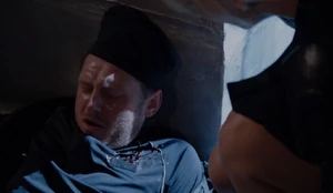 Pretending to have been attacked and knocked out during Leslie's assault.