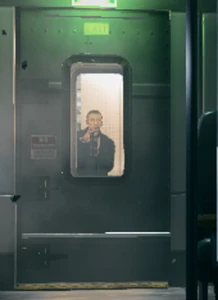 Solomon planting a bomb to stop Blackburn on the train.