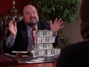 Lucre building a tower of C-Notes while explaining his plan to Kara Banks in his office