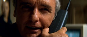 Payne taunts Jack on the phone after blowing up his friend, Harry Temple and Payne's first evil grin