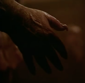 Lifeless hand hanging off the edge of the bed.