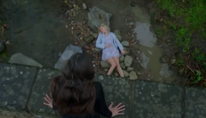 Meena looking down at Leanna's corpse shortly after murdering her.