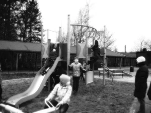 Slender Man standing in the background of a schoolyard.