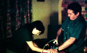 Trevor burns Little Mo on the hand with an iron.