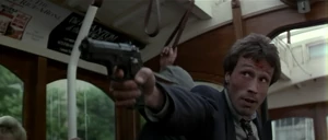 Korda about to shoot an innocent bystander while trying to escape in a tram.