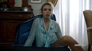 Villanelle coming out a suitcase.