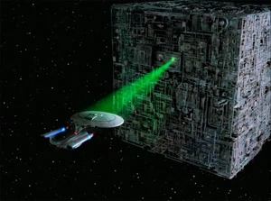 The Enterprise-D held captive by a Borg Cube's tractor beam.