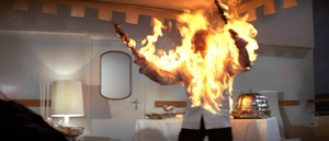 Mr. Kidd is set alight after failing to stab Bond with flaming skewers