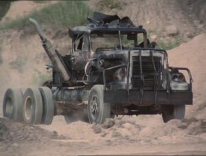 The damaged truck charges towards the survivors as the helicopter approaches.